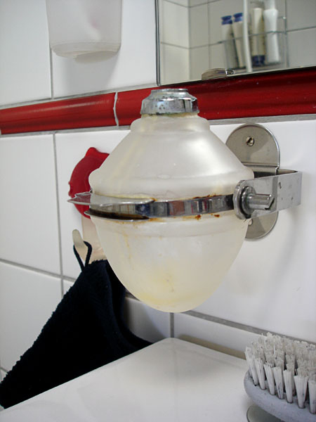 Wall-mounted soap dispenser that can be tipped.