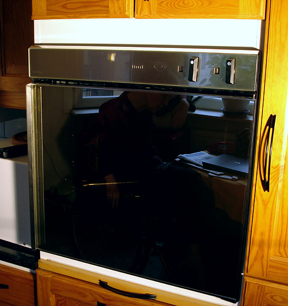 Oven in upper cabinet with side-hinged door