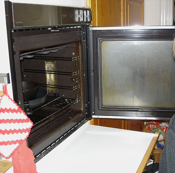 Oven door is open, pull-out board under the oven