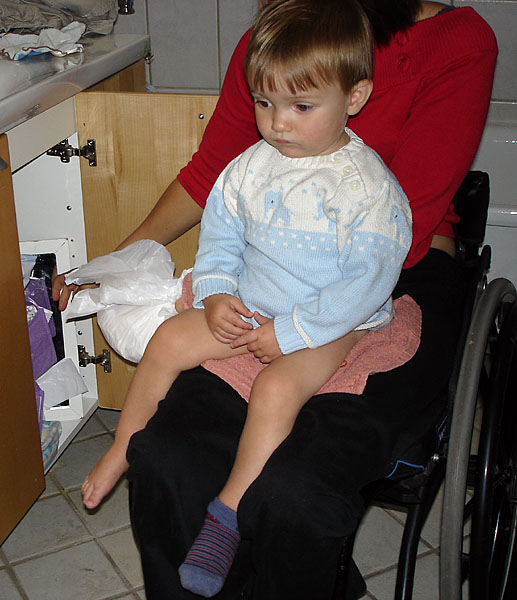 Child sits on user's lap; diaper is removed