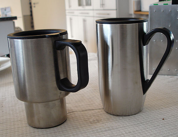 Two thermal stainless steel mugs with large plastic handles.
