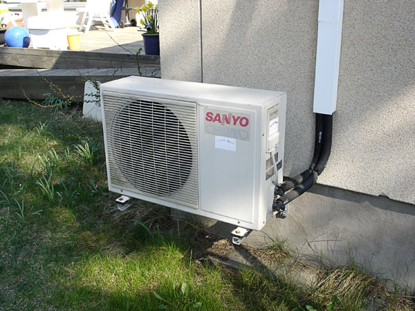 Air-to-air heat pump sitting on the bottom of the outer wall, outdoor unit