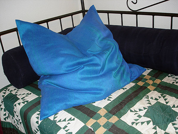 A large cushion on a bed