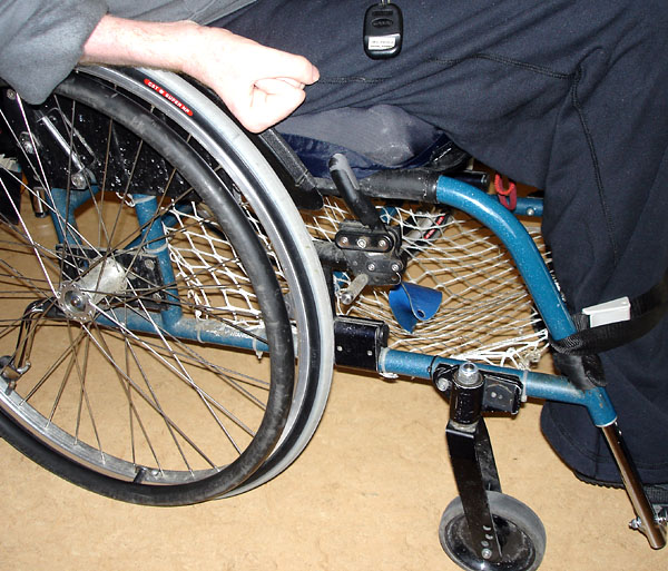 Wheelchair with net attached to frame under seat