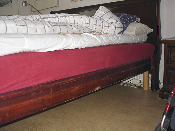 Wooden board on long side of bed