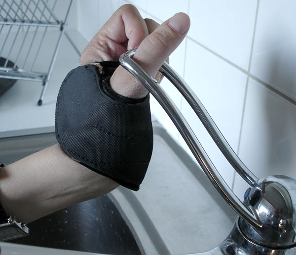 User's thumb in the handle of the single-lever faucet (close-up)