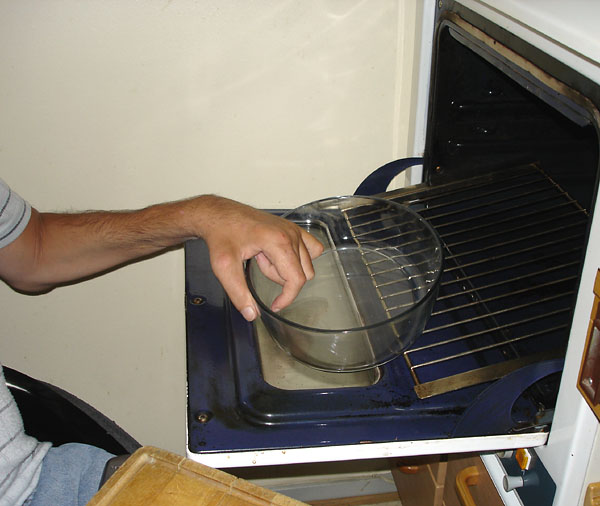 User slides the baking dish over onto the grill, which is pulled out from the oven