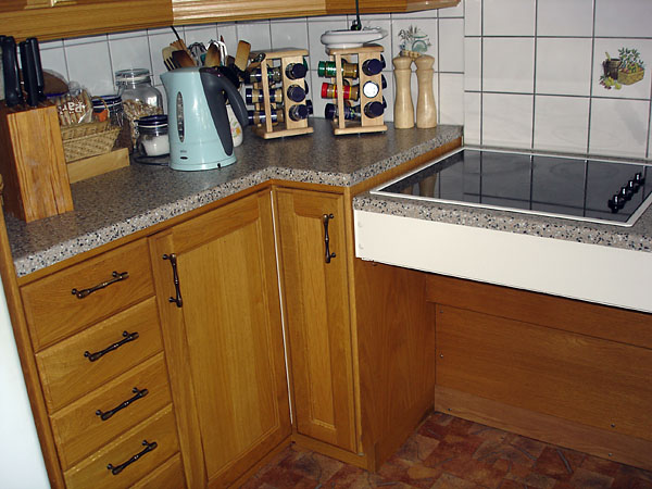 Adjustable height stove and fixed counter with cabinet