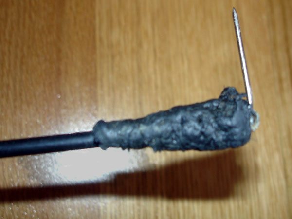 Needle taped to end of rod (close-up)