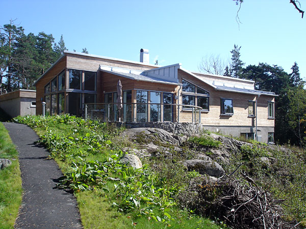 House with large windows on sloping lot, front view