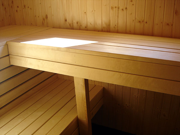 In a sauna a bench is folded against the wall