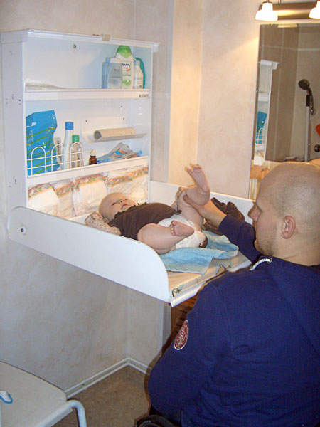 Wall-mounted hinged baby changing table