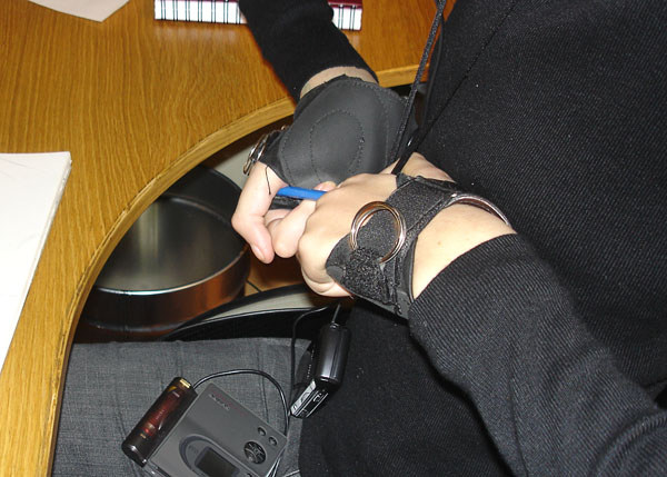 User fastens eraser to wheelchair glove