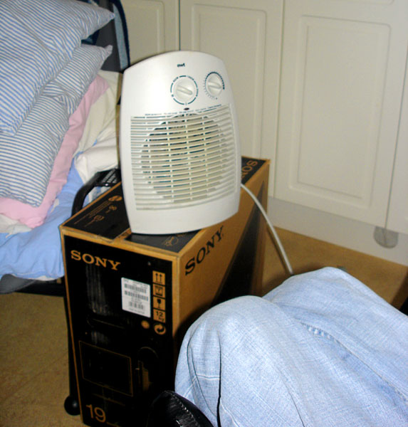 User sitting by heating fan