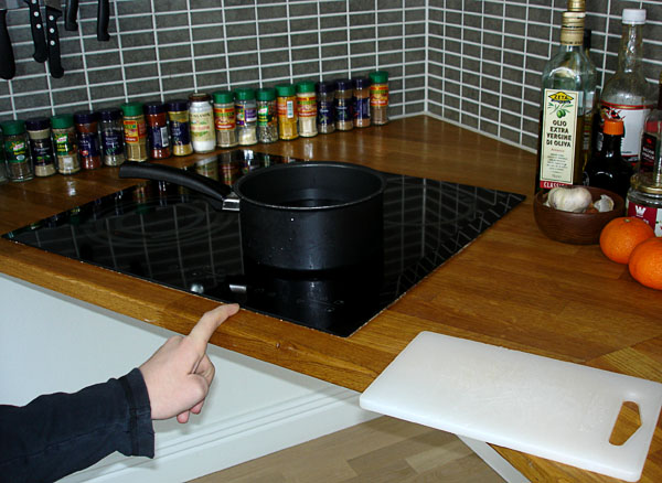 Pot on stove with cutting board next to it