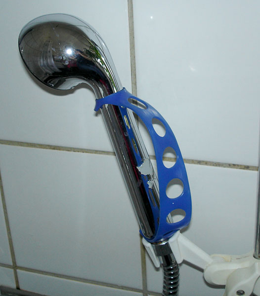 Plastic strap with holes attached in a shower handle