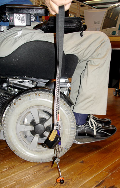 Användaren plockar upp en nyckel från golvet med hjälp av en magnet som sitter på ett band.