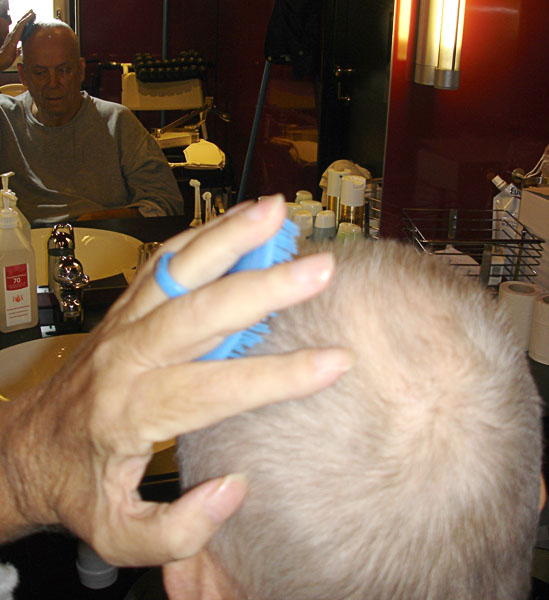 User with hair brush – viewed from behind