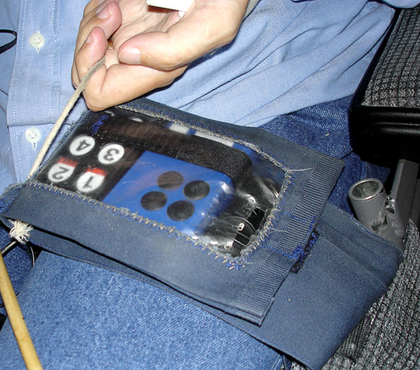 User puts remote control unit in a fabric bag on lap