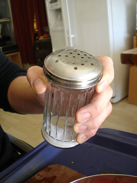 User with sugar shaker in hand
