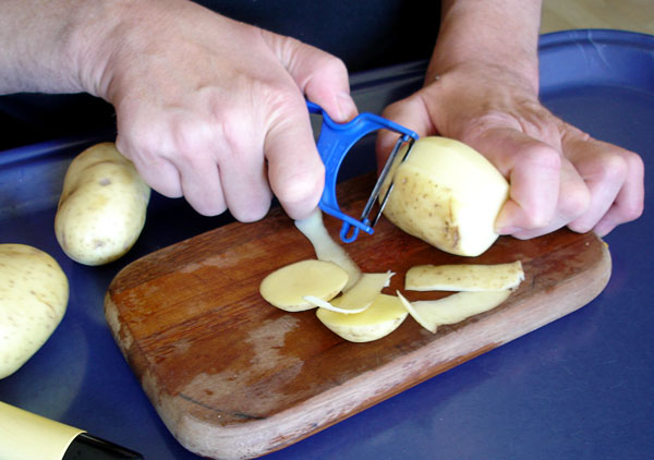 Användaren skalar potatis med avskurna kanter