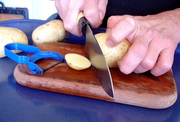 Användaren skär av kanterna på potatisen