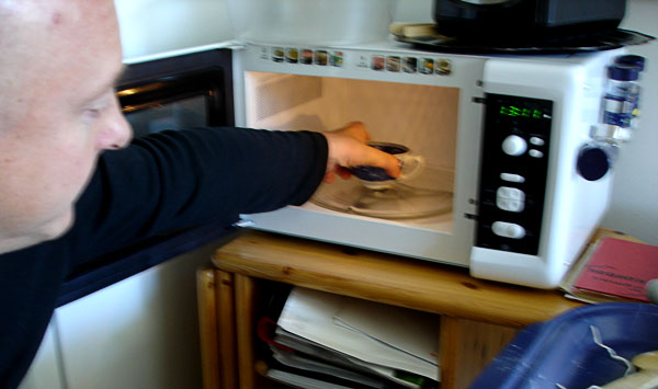 User removes cup from microwave oven