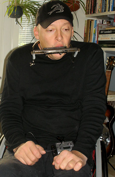 User plays the harmonica with the harmonica holder
