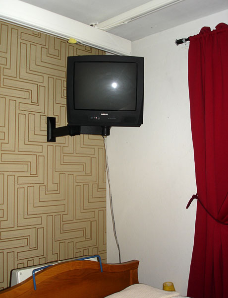 A TV mounted on a stand on the wall