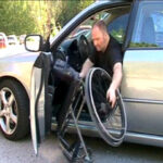 Lifting a wheelchair out of a passenger car