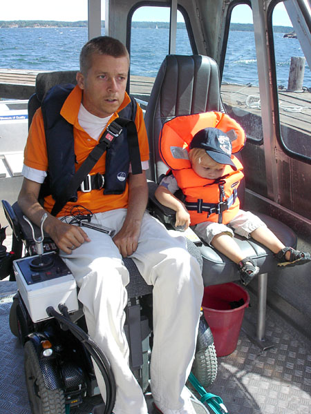 User with the boat's joystick on the wheelchair attachment