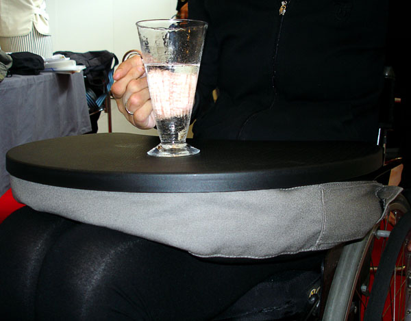 Tray placed on lap when person sits in wheelchair