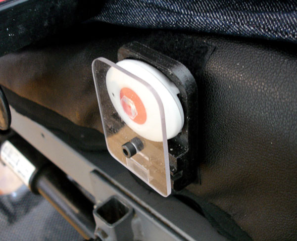 Anpassad portabel larmsändare fastsatt på rullstolsdynas sida.