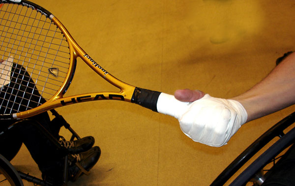 User with tennis racket taped to his hand