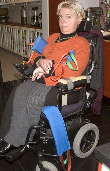 Helena sitting in the wheelchair; one sling under her thighs and one behind her back under her arms.