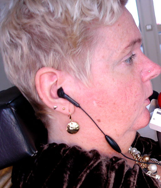 Close-up av Helena's huvud, telefonenes headset i öronen.