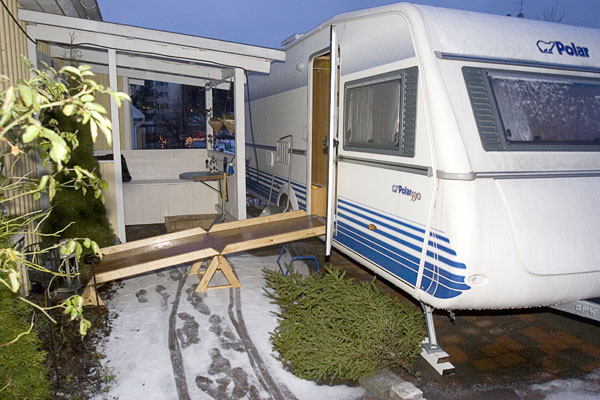 Husvagn med snickrad trä ramp vid dörren.