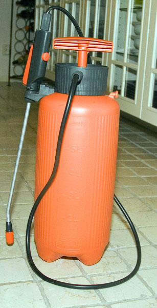 5-litre bottle-shaped pressure container with pump handle on top, long hose with nozzle, handle with trigger and lock.
