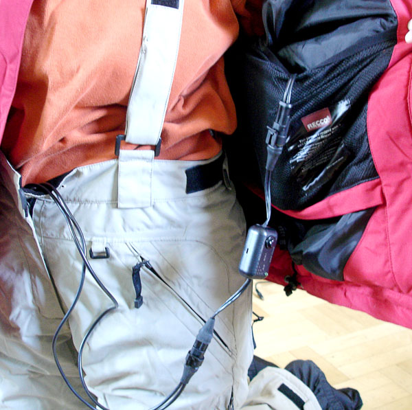 User shows battery cables which go from the legs to the jacket pocket