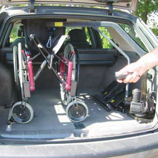 Användaren med fjärrstyrningen till rullstolskranen; foto från autoadapt, www.autoadapt.se