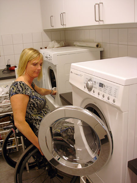 Användaren vid arbetsbänken mellan tvättmaskinen och torktumlaren