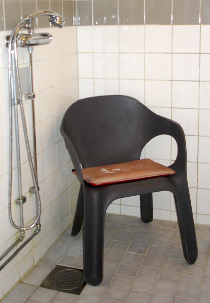 Self-inflating seat pad on shower chair
