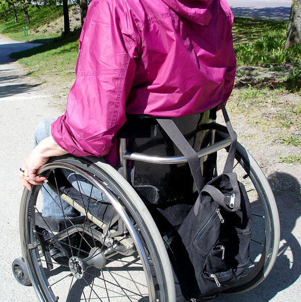 Användaren i sin individuellt anpassad rullstol, bakifrån