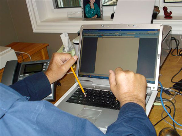 Användaren skriver på datorn med skrivpinnar