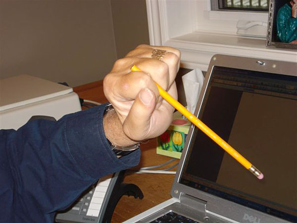 User holding a writing stick between index and middle finger.