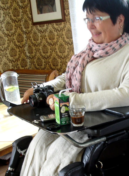Användaren med sin kamera på rullstolsbordet