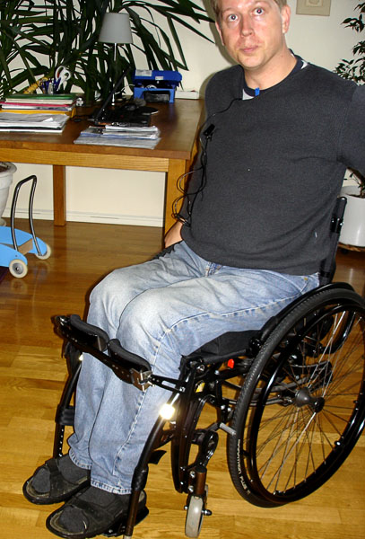 User sitting in standing wheelchair with knees stabilized