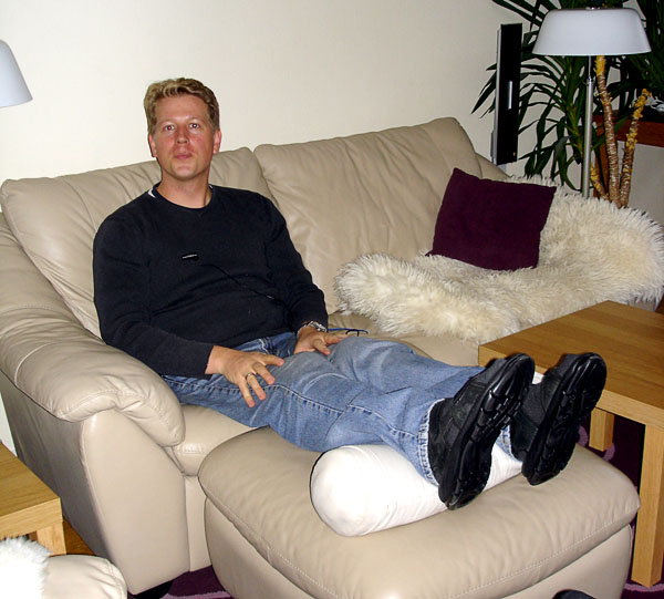 User on couch with roll cushion to relieve heels