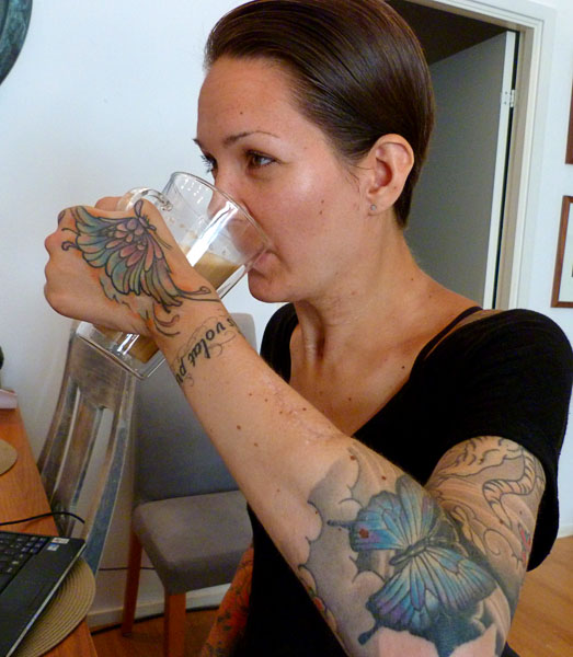 User drinks coffee from her insulated glass mug