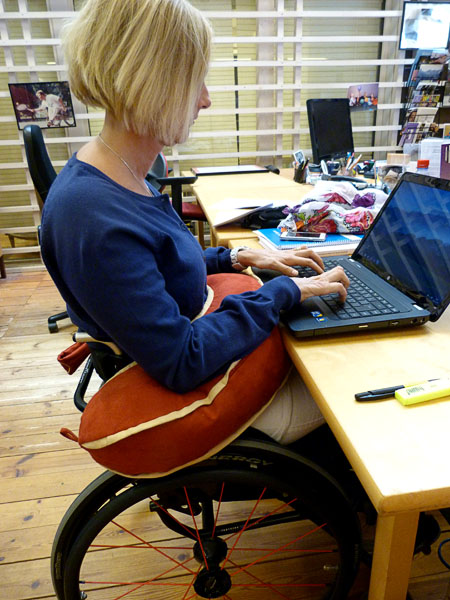 User with her laptop. Forearms resting on support cushion
